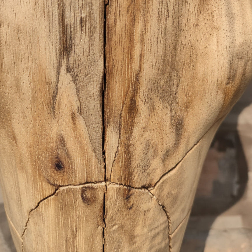 Close-up of hand-carved tribal wooden sculpture with natural grain and cracks