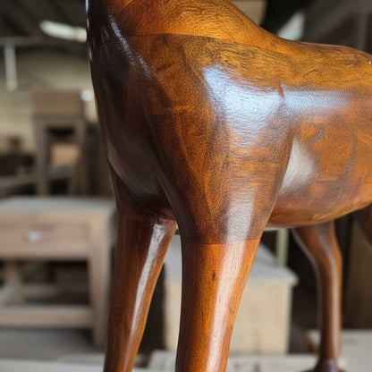 Handcrafted wooden animal sculpture with a polished finish in a workshop setting