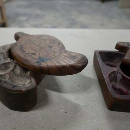 Handcrafted wooden tribal jewelry box with intricate carved design on a table