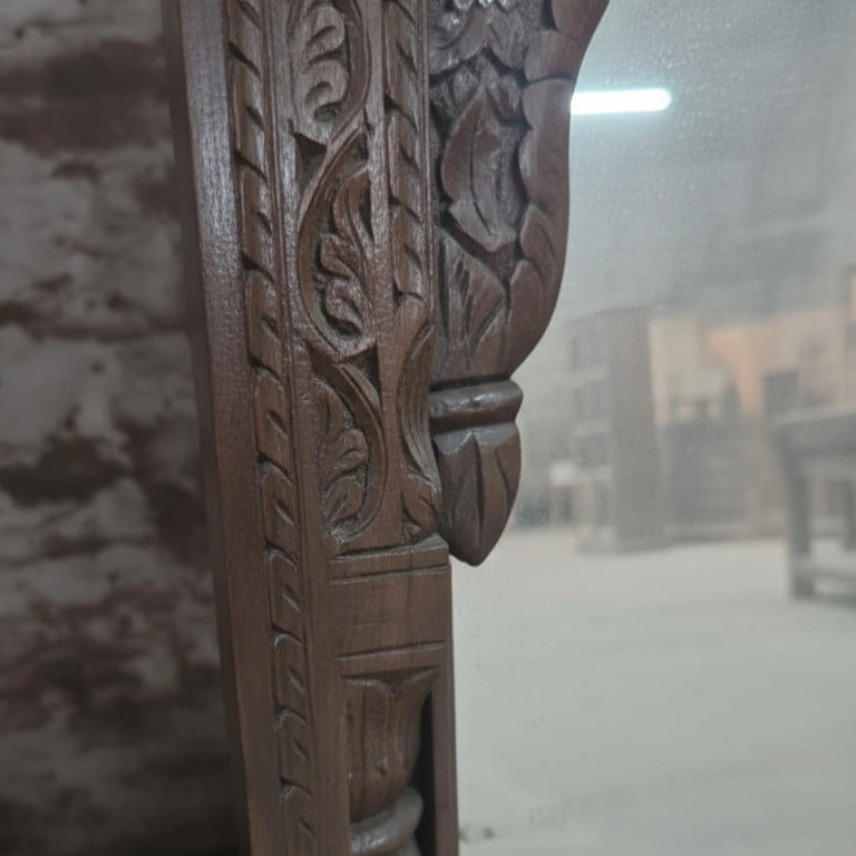 Close-up of hand-carved wooden frame with intricate leaf patterns, tribal handicraft decor