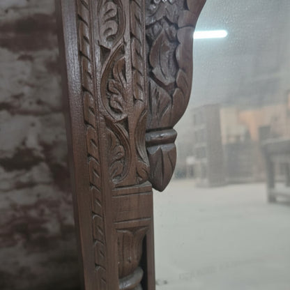 Close-up of hand-carved wooden frame with intricate leaf patterns, tribal handicraft decor