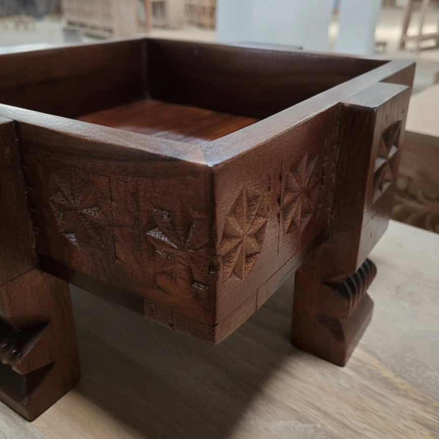 A close-up of the Ahaar Wooden Fruit Bowl showcasing detailed tribal handicrafts with intricate floral carvings on dark polished wooden decor.