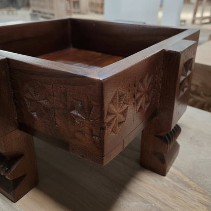 A close-up of the Ahaar Wooden Fruit Bowl showcasing detailed tribal handicrafts with intricate floral carvings on dark polished wooden decor.