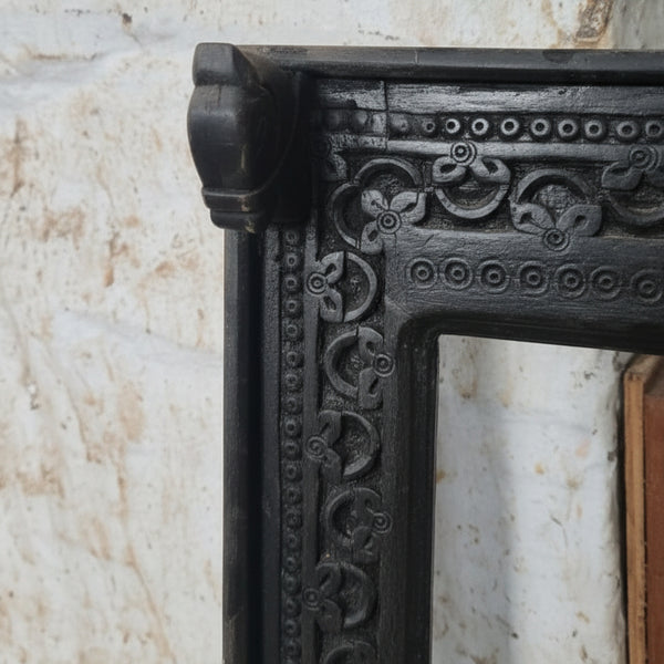 Ashva Wooden Mirror Frame featuring intricate hand-carved tribal wooden decor with detailed floral and circular patterns in a dark finish for elegant wall embellishment.