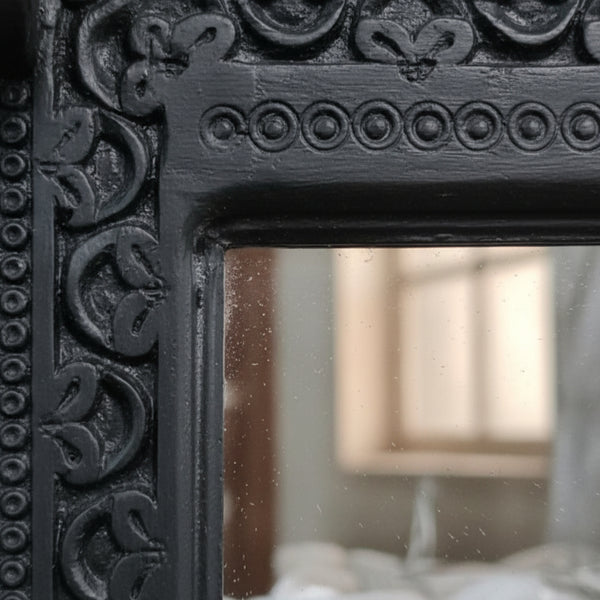 Close-up of detailed black hand-carved design on the Ashva Wooden Mirror Frame, showcasing intricate wooden decor craftsmanship.