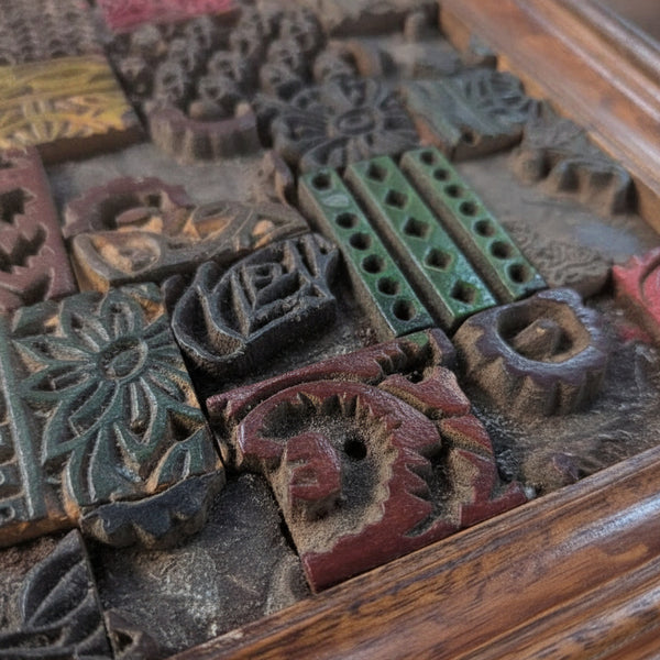 Close-up of colorful carved wooden blocks arranged in a mosaic pattern, showcasing intricate tribal handicraft details and textured decor.