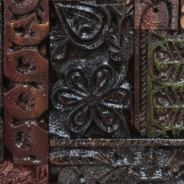Close-up of intricate hand-carved wooden patterns featuring floral and geometric designs in the Chhap Mosaic Wall Art, showcasing detailed tribal handicraft decor.