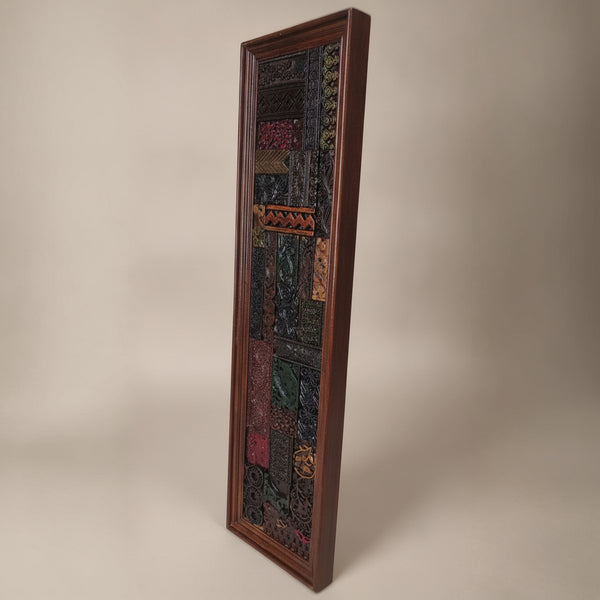 Tall rectangular wooden mosaic wall art featuring intricate tribal patterns and rich earthy tones, showcasing handcrafted detailed decor with a rustic appeal.