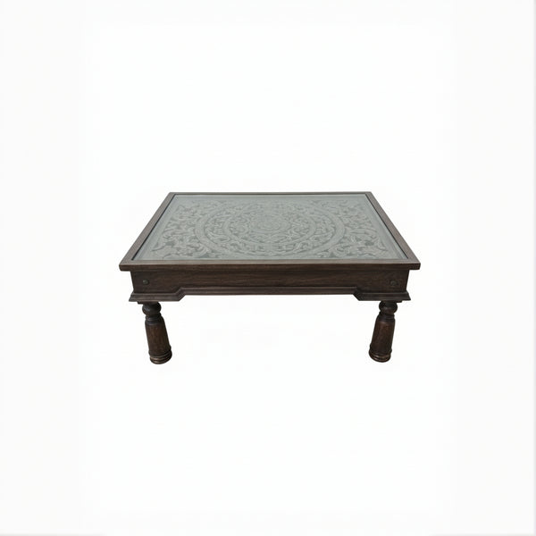 Handcrafted wooden table with intricate carved floral pattern and turned legs