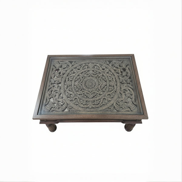 Handcrafted wooden table with intricate floral carvings, tribal decor style
