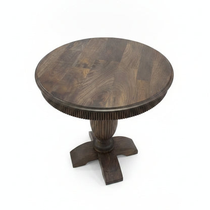 Round wooden pedestal table with a smooth finish and carved details on the central support, showcasing artisanal craftsmanship suitable for rustic or traditional decor.