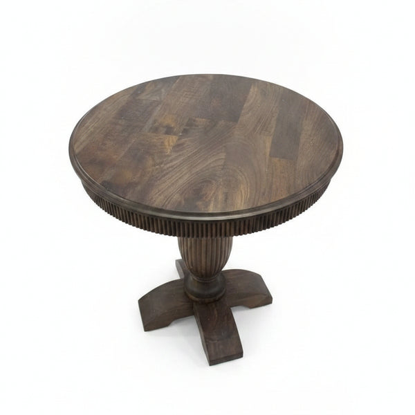 Round wooden pedestal table with a smooth finish and carved details on the central support, showcasing artisanal craftsmanship suitable for rustic or traditional decor.