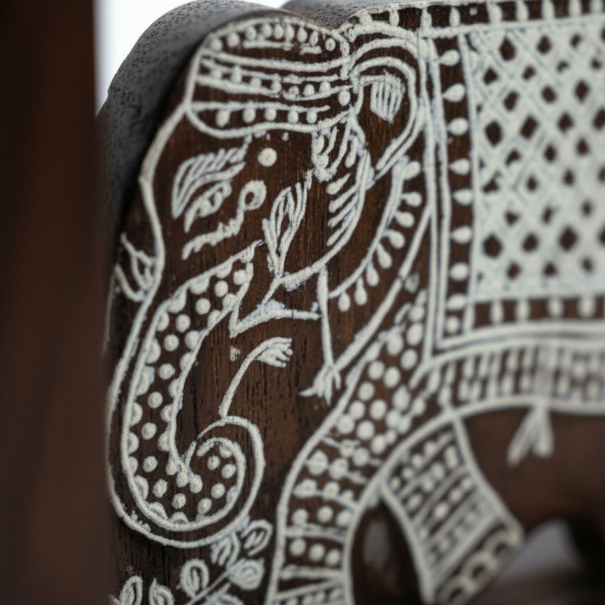Handcrafted wooden elephant figurine with intricate tribal white carvings