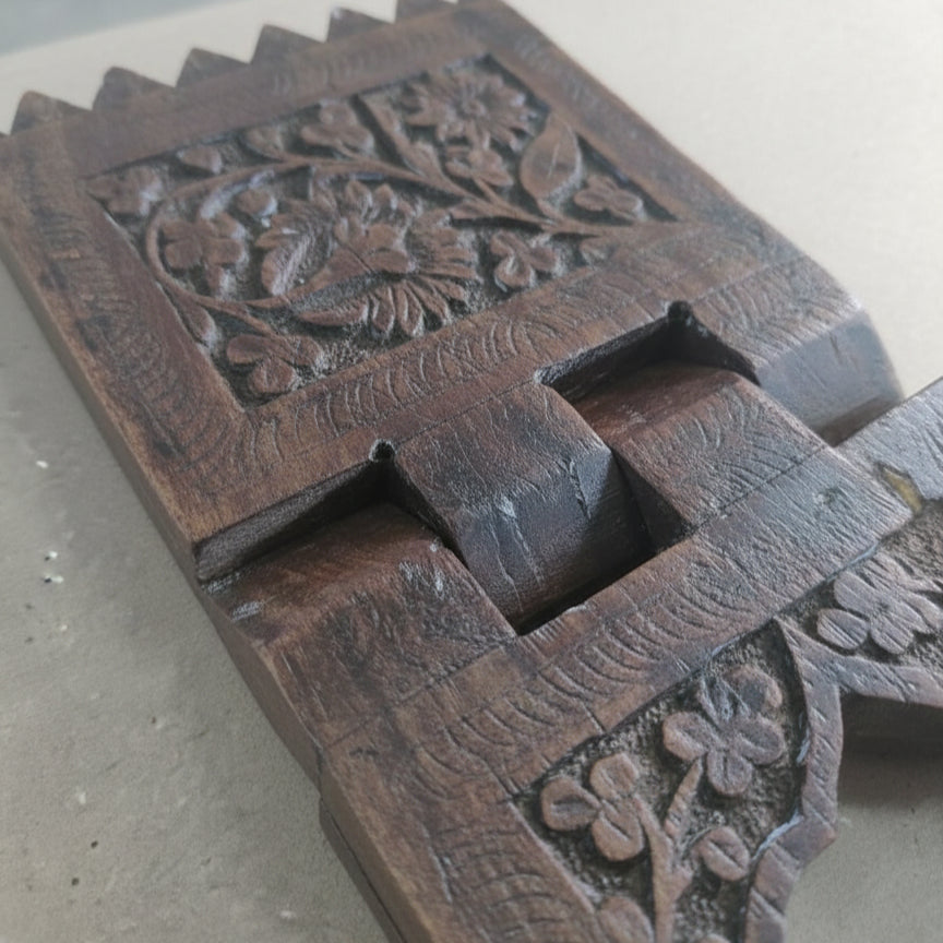 Rehal Wooden Carved Bookstand featuring intricate floral patterns carved from dark wood, showcasing traditional craftsmanship and ideal as a decorative wooden handicraft piece.