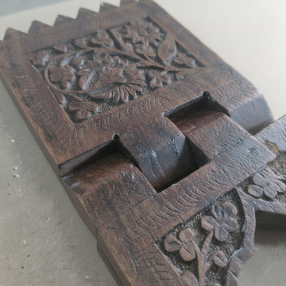 Rehal Wooden Carved Bookstand featuring intricate floral patterns carved from dark wood, showcasing traditional craftsmanship and ideal as a decorative wooden handicraft piece.