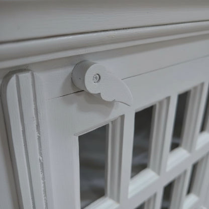Handcrafted white wooden cabinet with glass panels and carved latch detail