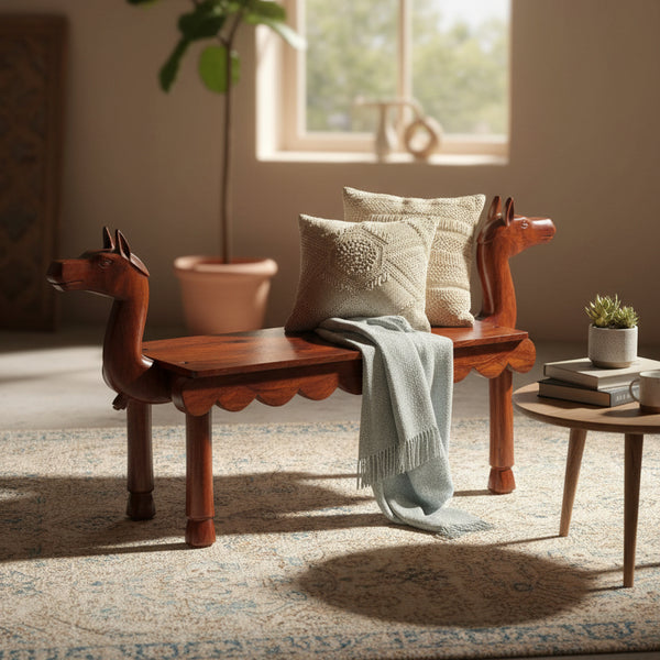 Vahana Carved Wooden Bench featuring intricate tribal handicraft, rich wooden finish, adorned with cozy cushions and a soft throw, ideal for stylish home decor.