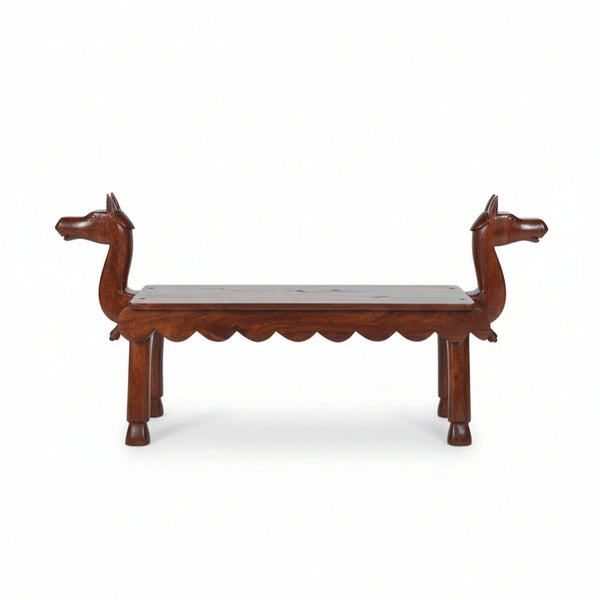 Vahana Carved Wooden Bench featuring intricate camel head carvings on each end, handcrafted in rich wood, ideal as a unique tribal handicraft decor piece.