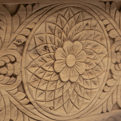 Intricate floral mandala pattern carved on natural wood, tribal handicraft detail